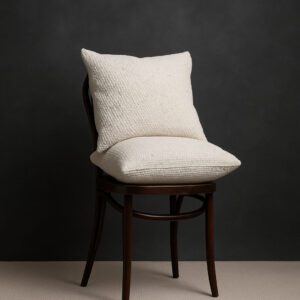 Két darab 50x50 cm-es, fehér pamut párna egy sötétbarna vintage Thonet széken, stúdiófotón, lakberendezési dekorációhoz