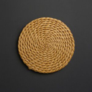Kézzel szőtt, gyékényből készült vintage edényalátét sötétszürke háttérrel, 20 cm átmérőjű, természetes lakásdekorációs kiegészítő