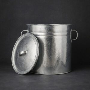 Galvanizált fém szűrős bádog edény, vintage stílusban, sötétszürke háttér előtt.